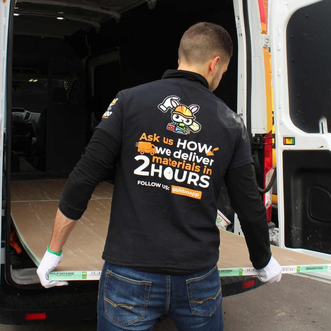 Biiibo staff unloads drywall during a building material delivery.